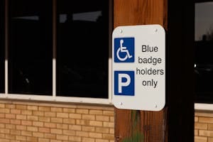 A sign indicating parking for blue badge holders only outside a building.