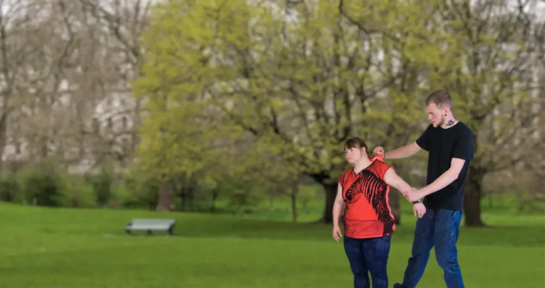 Man bullying a woman in a park.