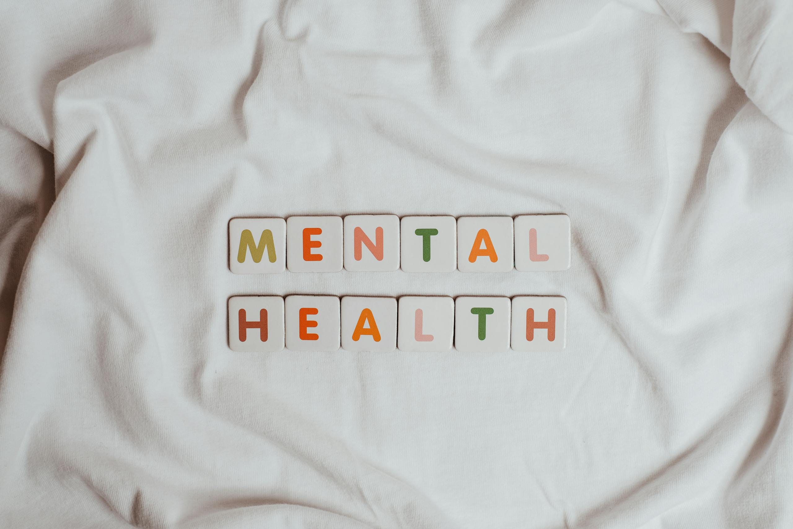 Close-up of 'Mental Health' text on cloth, symbolizing calmness and self-care.